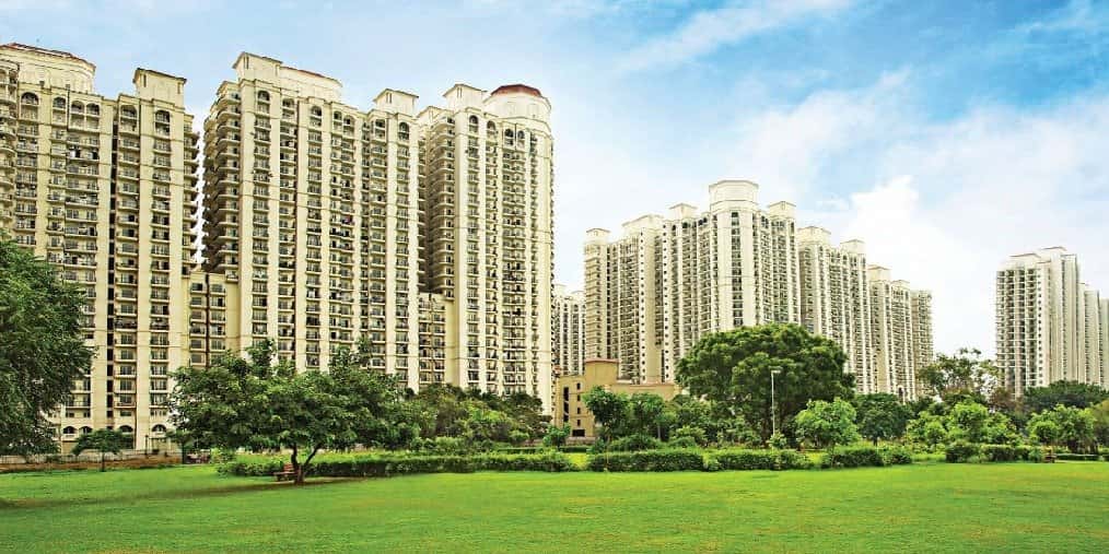 DLF One Midtown — residential towers beyond a green lawn