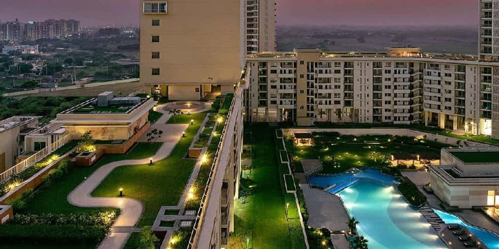 Experion Windchants — towers over a landscaped podium and pool at night