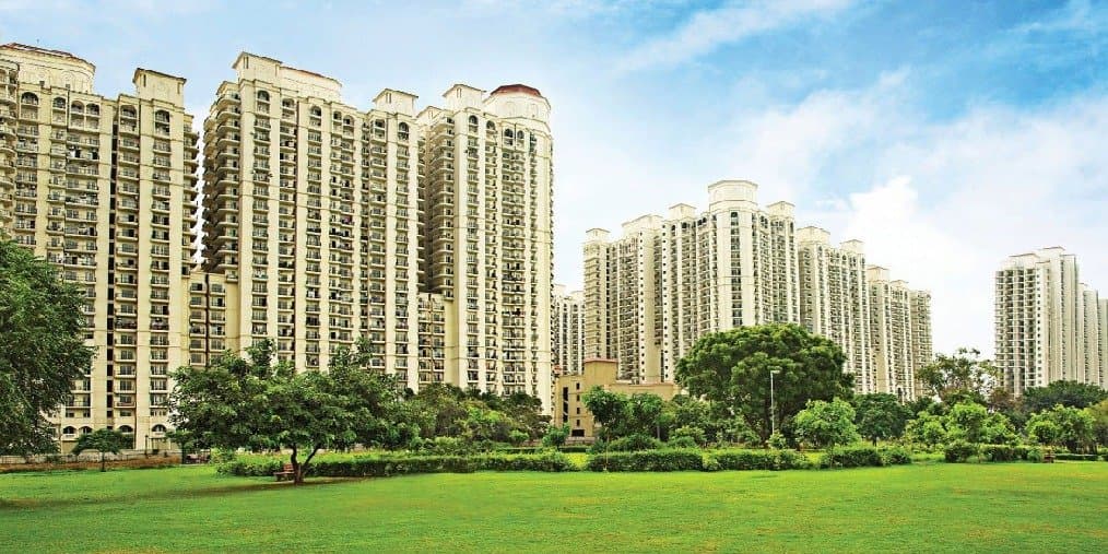DLF One Midtown — residential towers beyond a green lawn